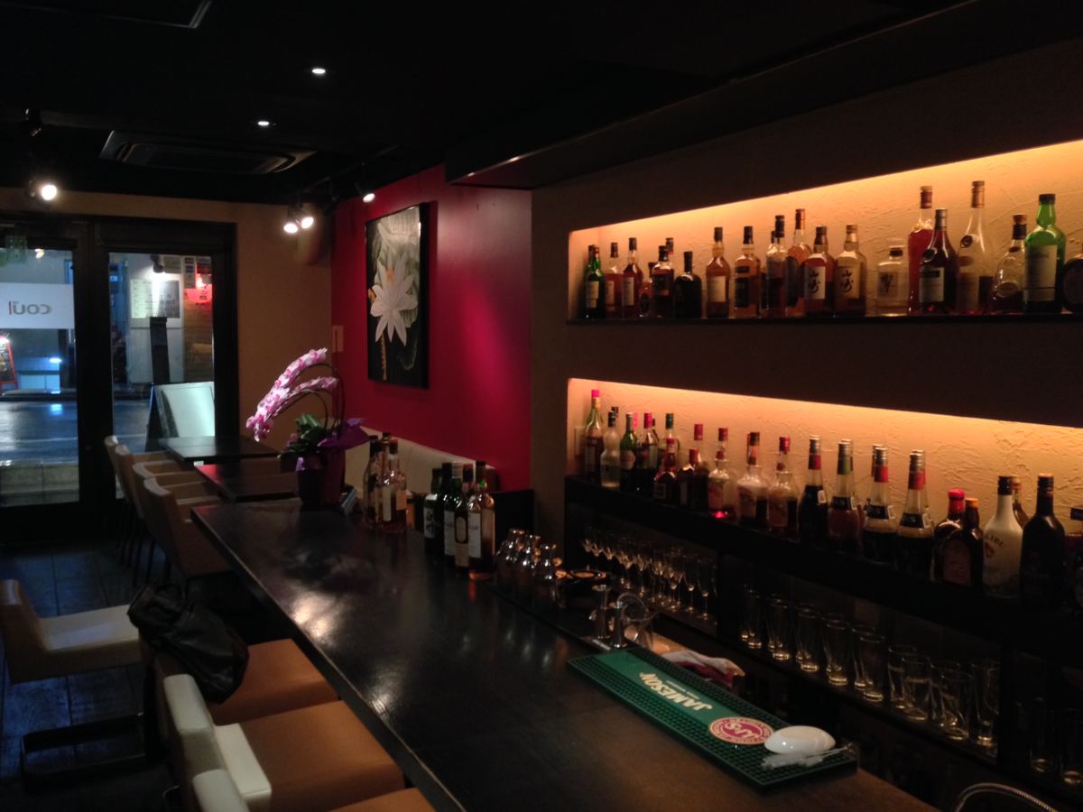 Bar Chip In の店内。木のカウンターと壁一面のボトル棚